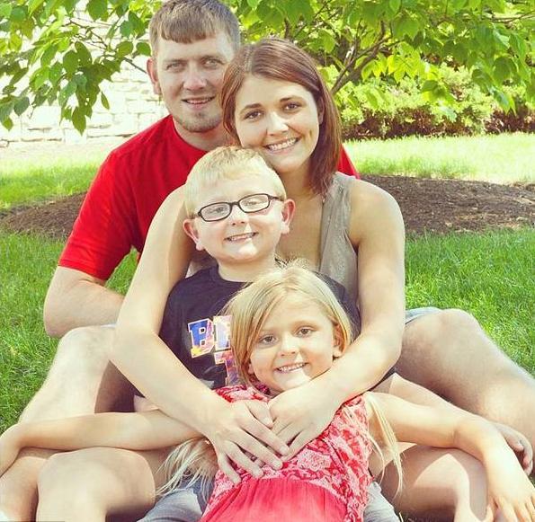 一張富有爭議的照片:妻兒面帶微笑與丈夫遺體合影