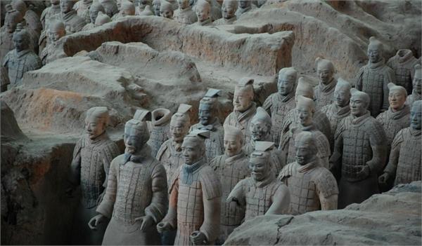 參觀過秦始皇陵兵馬俑的人都會知道,在幾千個兵馬俑中,竟然是千人千面,沒有一個人的面部是雷同的,雖然在秦代陶塑工藝已經相當成熟,但要實現那么多的兵馬俑面部輪廓不一的依舊難度非常大,因此,有傳言稱這些兵馬俑中其實存在活人俑,那么這些活人俑究竟存不存在呢? 為什麼秦始皇陵會有兵馬俑? 人殉是伴隨原始公有制的瓦解而萌芽,至奴隸制建立而盛行的一項殘酷的喪葬制度 。人殉最興盛的時代是殷商時期,商代貴族大墓中都有殉人。在安陽殷墟工陵區內,已發掘的十幾座大墓中被生殉、殺殉的多達五千餘人。不過這些習俗慢慢被廢除,到秦代出現以俑殉葬,即用陶俑、木俑等來代替人殉。“俑”的本意就是人殉,當人殉逐漸淡出人們的視野之後,“俑”便成了墓葬中陶塑、石雕、人像的專有名詞。秦兵馬俑就是以俑代人殉葬的典型,也是以俑代人殉葬的頂峰。 關於活人俑的兩個傳說 傳說一 隨著人殉習俗的逐漸廢除,但又要維持帝王尊嚴,在塑造兵馬俑的時候就想了個辦法,就是把活人身上裹上布然後用泥封住,再放到窯爐里燒,最後在塗上顏料,用這些活人俑用來陪葬。這些活人包括了死囚、罪人和宮奴等。秦律十分嚴酷,因觸犯秦律而遭遇下獄的死囚和罪犯極有可能能夠滿足這個需要。 傳說二 眾所周知,秦始皇是追求長生不老的,在求取仙藥的過程中,一些方士會採取活人做祭品,用他們來守護祭壇,製作的過程和前面的傳說是一樣的,只不過這個要求更嚴格,在製作過程中為了防止魂魄逃散,會將人的六識完全封死,製成的活人俑能夠讓死者永不超生。這樣製作的活人俑更殘忍恐怖,所以沒有放入殉葬坑中而是放在了位於秦宮地下的護國祭壇周圍。 那么活人俑存真的存在嗎? 科學上現在已經證實在古埃及等文明中活人俑是確實存在的,但是秦始皇陵中的兵馬俑裡面有沒有活人俑還不好說,兵馬俑經過秦末的農民起義的破壞後現存的數量已經不多,而且都十分珍貴,考古人員無法對其一一進行驗證。相信時間可以證明,未來,兵馬俑要真存在活人俑,肯定會被證實的。